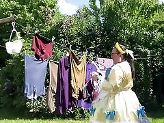 In an outfit with a yellow and blue maid dress to hang the laundry.