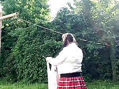 In schoolgirl outfit to hang the laundry