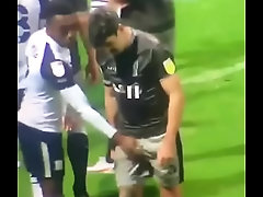 Pegando na rola do jogador no campo de futebol