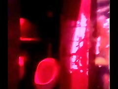 Amateur boy lending hand to his friend pissing in public toilets'_ urinal